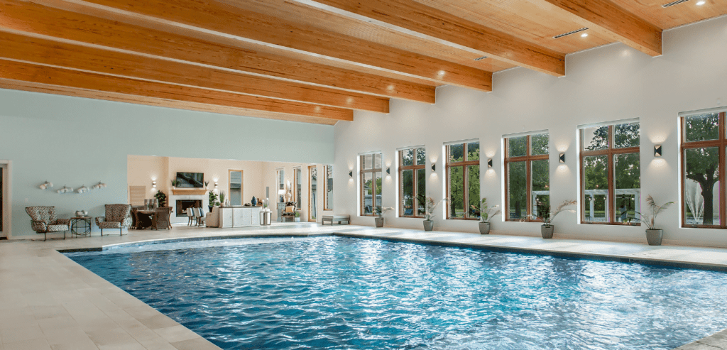 Lavish climate-controlled indoor pool in Waxahachie estate featuring 65,000 gallons, fountains, ambient fiber-optic lighting, living space with fireplace and kitchenette, and open views—ideal for luxury entertaining and joyful family fun.