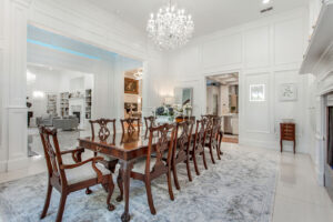 Luxurious formal dining space in Waxahachie estate with grand table seating, sparkling chandeliers, marble floors, and elegant design for sophisticated entertaining and special occasions.
