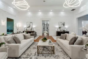 Grand living room in Waxahachie luxury estate featuring hardwood floors, crystal chandelier, refined décor, and sweeping views down the expansive hallway—perfect for elegant gatherings and family living.