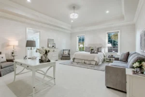 Spacious secondary bedroom in Waxahachie luxury home with hardwood floors, generous closet space, large windows with natural light, and refined décor—perfect for family or guests.