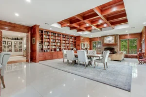 Grand executive office in Waxahachie luxury estate with coffered wood ceilings, paneled wood walls, brick fireplace, private entrance, elegant seating, large windows, and sophisticated finishes for business and family.